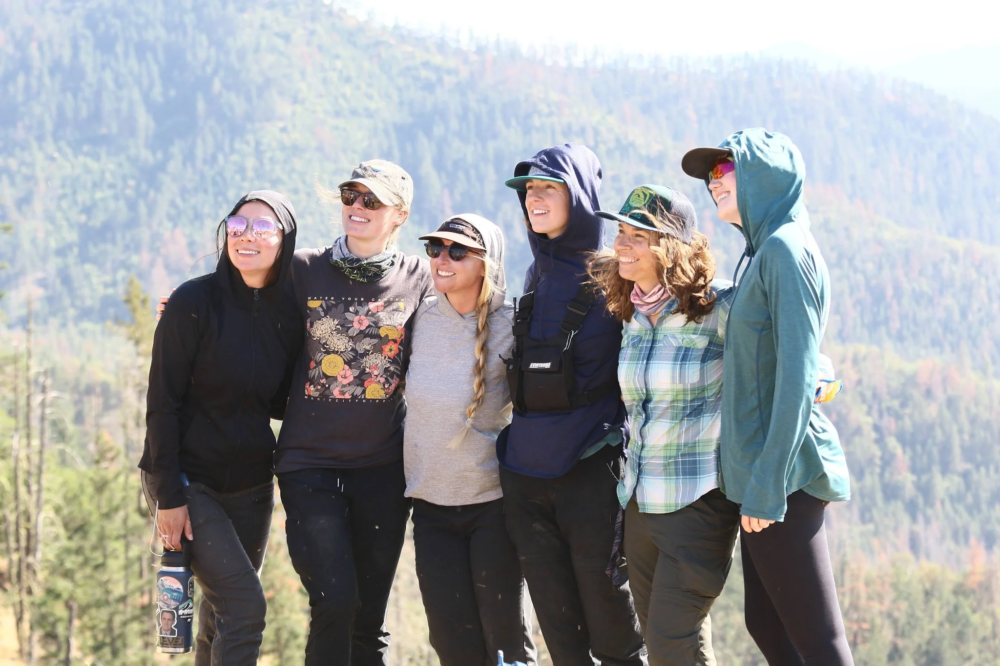 Amy Swan, Human Systems Strategist, standing alongside five other women all smiling in a pacific northwest mountain landscape.